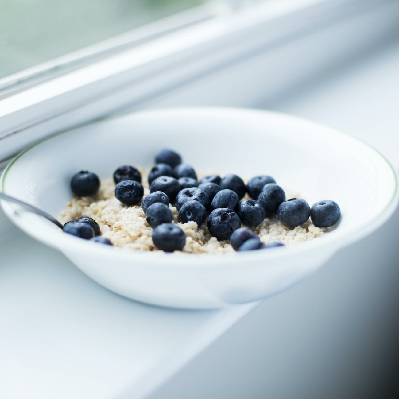 Grain-free oatmeal with blueberries in a bowl on a windowsill